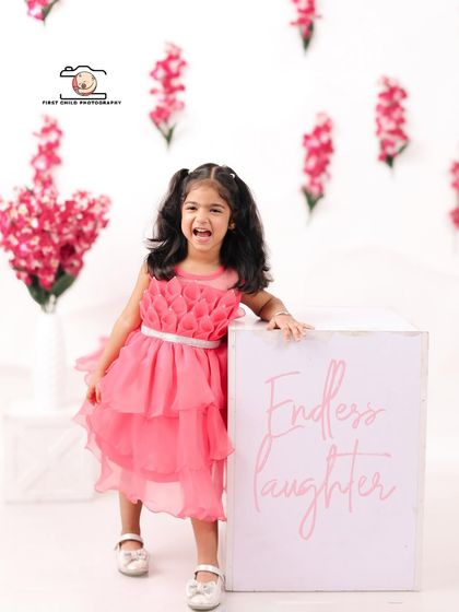 A burst of "Endless Laughter" from the birthday girl. Dressed in a beautiful pink dress, she shares a joyful, open-mouthed laugh during her third birthday studio session.