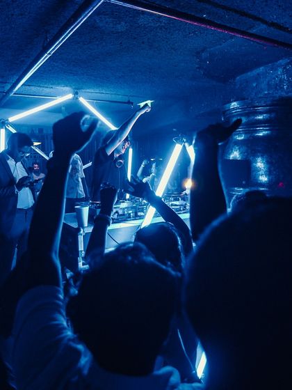 A moody, blue lit shot from a monsoon party. This image captures the vibe of a late night, high energy club set.