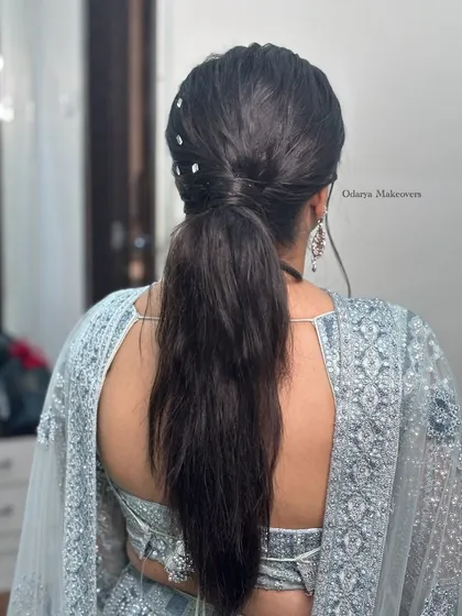 A back view of the trendy slick ponytail with mirror accessories. This is a chic and modern hairstyle for any party.