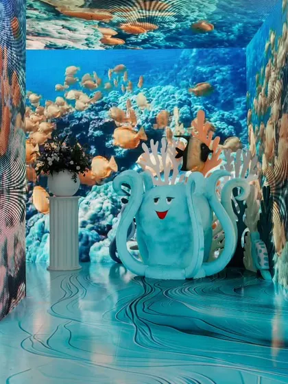 An immersive entryway designed to look like an underwater tunnel with a digital aquarium effect. This creates a 'wow' moment as guests transition from the real world into the party.