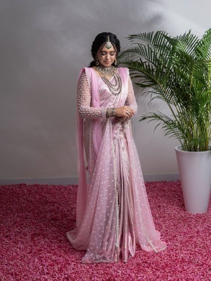 From my Maharani Series, this light pink Kanjivaram saree is where tradition meets modern artistry. I've adorned it with intricate zardozi and paired it with a net handwork blouse and a regal dupatta, a tribute to the ancient queens of India.