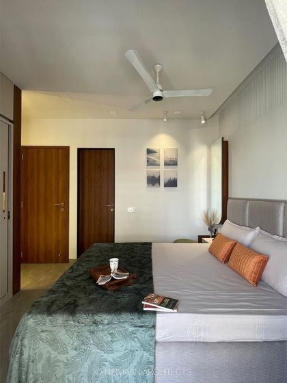 This master bedroom uses a calm, neutral palette and simple decor to create a minimalist and serene retreat. The focus is on clean lines and a clutter-free environment.