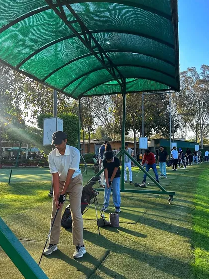 A young golfer practices his swing under one of our shaded canopies on a busy Sunday.