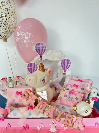 For a magical birthday, I created this unicorn-themed hamper for Samaira. It's filled with pastel colors, a plush unicorn, personalized name banner, and other whimsical unicorn party decorations.