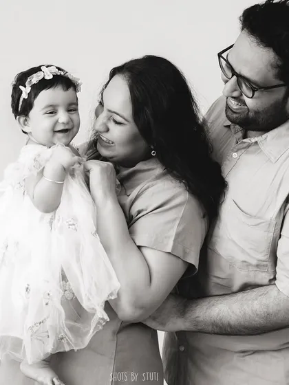 A candid moment of laughter and love. This black and white photo freezes a genuine interaction between the family, creating a memory that feels alive.