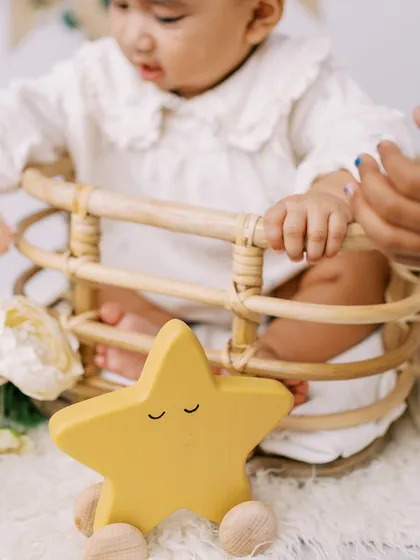A close-up on a wooden star toy from the six-month session, showing the simple, natural props I use.