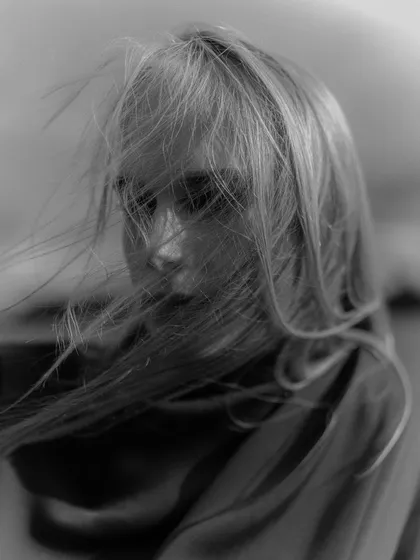 An atmospheric portrait of model Holly Sofia, captured on black and white film. The motion from the wind in her hair and the soft focus demonstrate the rich, textural quality that film photography provides.