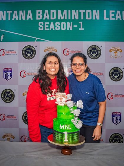 Here I am with a happy client at the Montana Badminton League event, standing proudly next to the custom two-tier cake I created for their celebration.