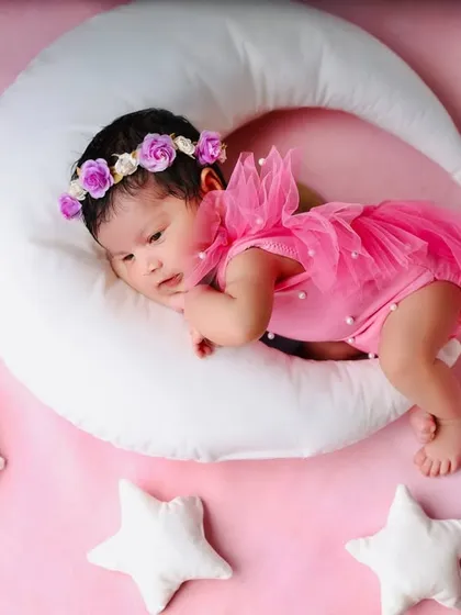 A different pose in the moon and stars setup, with the baby lying on her side. This shows the versatility of a single prop to create multiple unique shots.