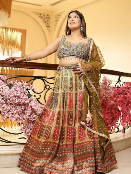 A client posing in a beautiful multi-colored printed lehenga. The heavy embroidery on the blouse elevates the look, making it suitable for a sangeet or mehendi.