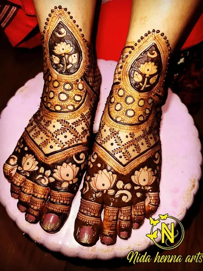 This bridal feet design features large paisley shapes filled with lotus motifs. The toes are also intricately detailed, completing the rich bridal look.