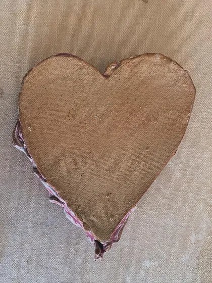 A heart-shaped dish with a bow carved in the center, glazed in a rich magenta.