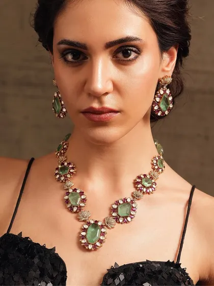 A contemporary necklace set from the Emrosia collection, featuring carved emeralds and rubies in a modern floral design.