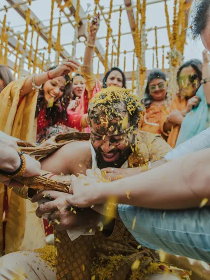 The 'phoolon ki haldi' in full swing, with the groom being playfully covered in flower petals.