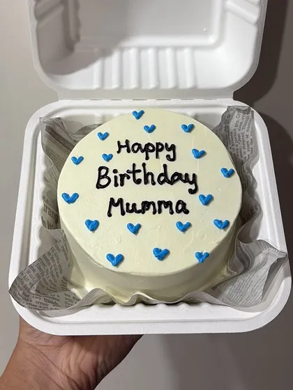 A simple and sweet bento cake for a mother's birthday. The message 'Happy Birthday Mumma' is written in clean script, surrounded by blue hearts.