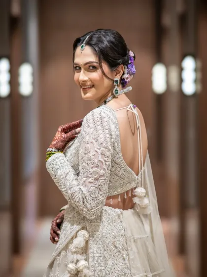 A bride's confidence is everything. I love capturing that final look back, a mix of excitement and elegance. This stunning bridal portrait showcases the intricate details of the wedding lehenga and the bride's radiant smile.