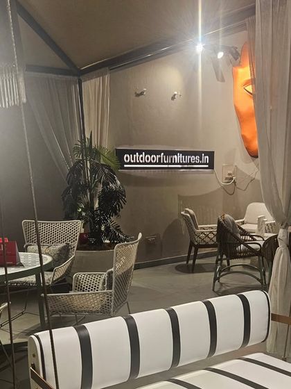 A view of our showroom featuring a variety of seating options, including a modern swing and a classic cafe set, demonstrating the breadth of our collection.