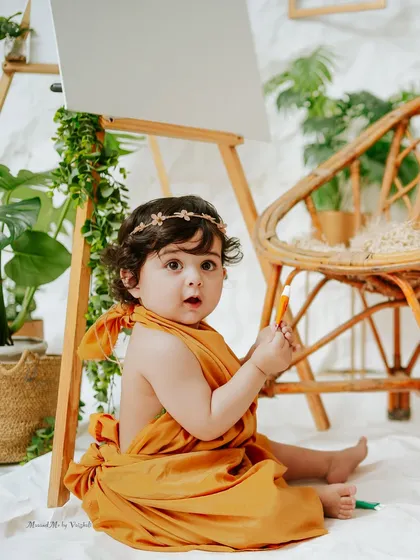 Meet the little artist. This creative, boho-inspired setup with an easel and plants is perfect for capturing a curious and expressive baby's personality.
