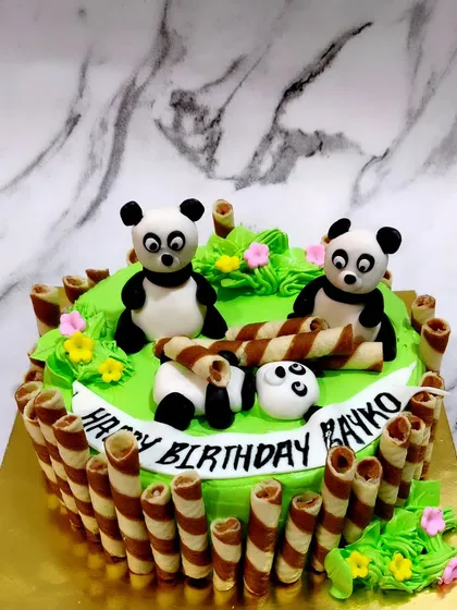I'm not lazy, I'm just panda-like. 🐼 A super cute panda-themed cake for someone who loves to chill, surrounded by chocolate wafer rolls.