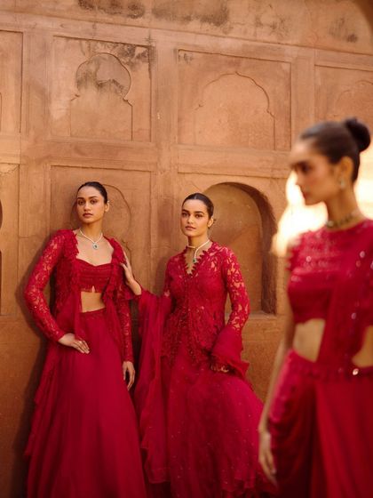 This composition shows the interplay between different outfits from the same collection. The focus is on how the various red ensembles complement each other, perfect for a coordinated bridal party.