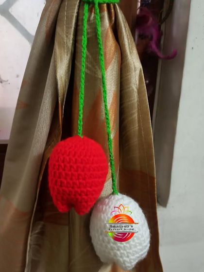 A simple yet beautiful curtain tie-back design featuring two crochet tulips, one in red and one in white. This is a lovely, minimalist way to bring a floral touch to your windows.