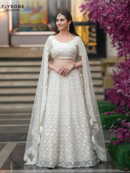 An ethereal all-white lehenga with a cape-style dupatta. This is a perfect outfit for a daytime event or a themed party, offering a celestial vibe.