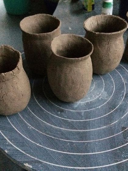 A collection of small, hand-built pinch pots. This is one of the most fundamental pottery techniques, relying only on the potter's hands to shape the clay.