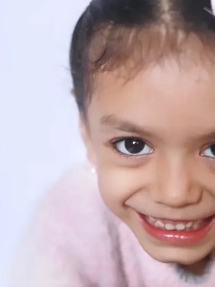 An infectious, wide-eyed smile that lights up the frame. This close-up portrait is all about capturing that pure, unfiltered happiness that is so unique to childhood.