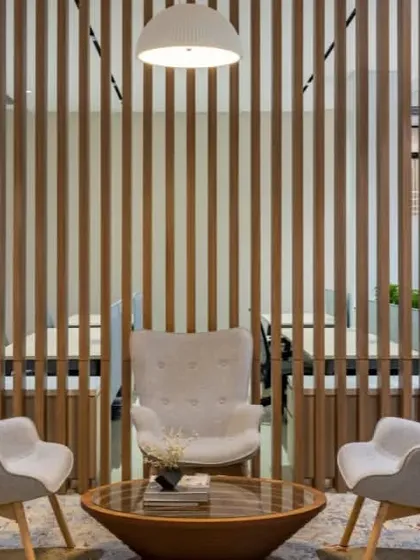 A simple yet elegant lounge setting, perfect for a quick, informal meeting. The slatted wood background adds texture and warmth to the space.