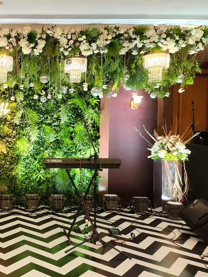 Another view of the green-themed Sangeet stage, highlighting the placement of musical instruments and the overall lush, garden-like feel.