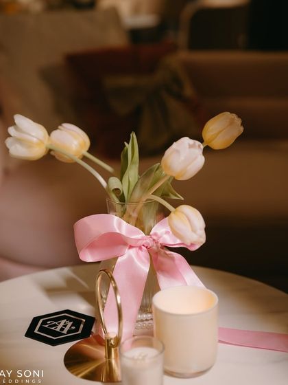 A simple vase of tulips tied with a pink bow, a small but charming detail that reinforces the "Big Bow Affair" theme.