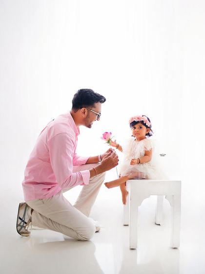 A father's sweet gesture, offering a single pink rose to his little girl.