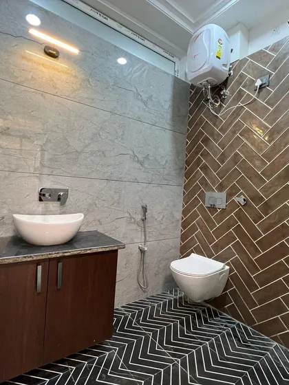 I love creating contrast with tiles. In this bathroom, the warm, wood-look herringbone tiles in the shower area stand out against the cool grey wall tiles and the bold black-and-white chevron floor.