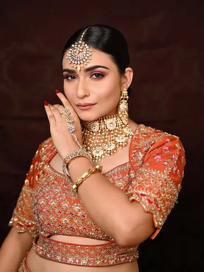A direct, confident gaze. This shot highlights the clean lines of the makeup, with sharp brows and a subtle contour that defines the face beautifully against the traditional attire.