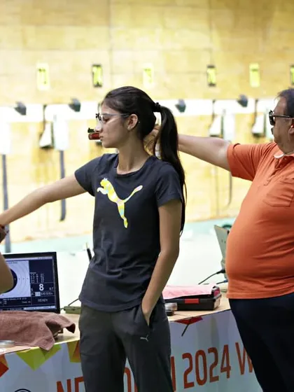 Guidance is key, especially for upcoming talent. Here, a young pistol shooter gets some advice during a match. I strive to create an atmosphere that is not just competitive but also supportive, helping athletes grow at every stage of their journey.