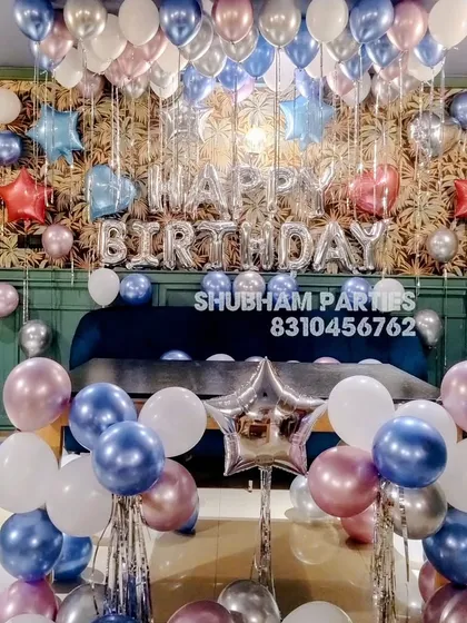 A beautiful room decoration with metallic blue, pink, and silver balloons for a birthday.