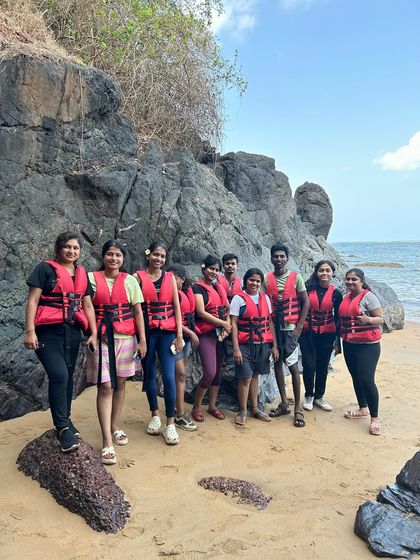 Our group ready for adventure in their life jackets, posing on the rocks of a secluded beach in Gokarna.