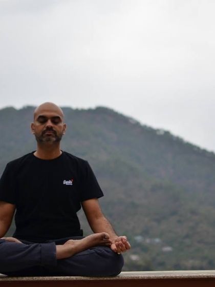 A student meditates with the mountains behind him, finding stillness and peace during one of our retreats.