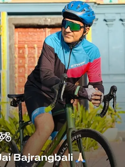 "Jai Bajrangbali." A close-up of a cyclist in front of the temple, capturing the spiritual side of our journey.