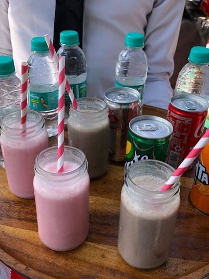 Milkshakes served in cute mason jars with striped paper straws. A perfect, kid-friendly drink option for the farm-themed birthday celebration.