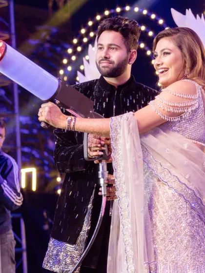 Having a blast at the sangeet. The bride is all smiles, enjoying the party with a CO2 gun, looking fabulous.