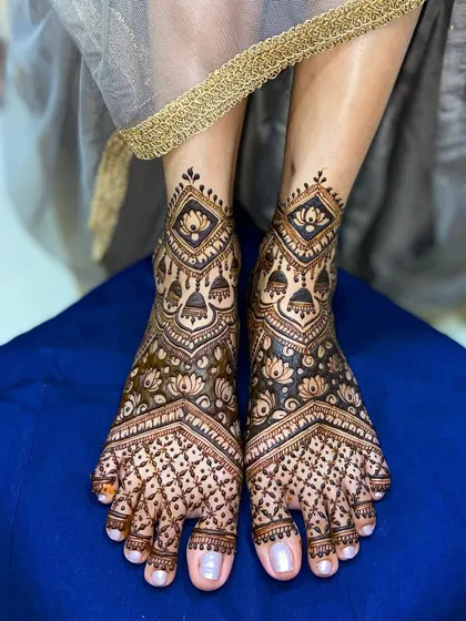 An example of my intricate foot mehandi. This design features geometric jaal work, lotus motifs, and hanging jhumkas, perfectly complementing the henna on the hands for a complete bridal or festive look.