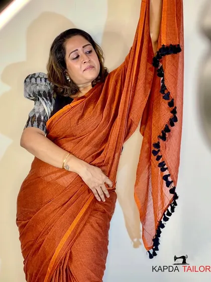 Grace meets tradition with this stunning rust orange saree. Paired with a black Ikat blouse, this combination is perfect for any occasion, from a festive gathering to an elegant evening event.