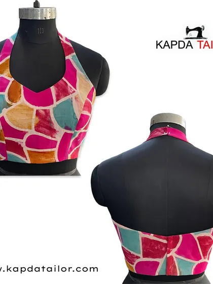 This halter-neck blouse features a vibrant, abstract print in shades of pink, blue, and orange. The backless design makes it a bold and stylish choice for cocktail parties or summer events.