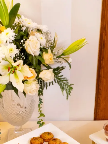 A beautiful floral arrangement next to a platter of desserts at our event with L'Opéra, a renowned French patisserie. A perfect partnership of elegance and taste.