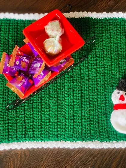 A festive green placemat with a snowman, perfect for adding holiday cheer to your meals.