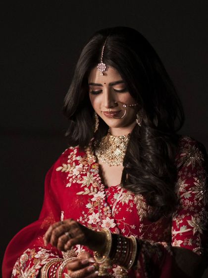 A candid moment of the bride adjusting her jewelry. This simple, elegant shot captures a quiet moment of preparation.