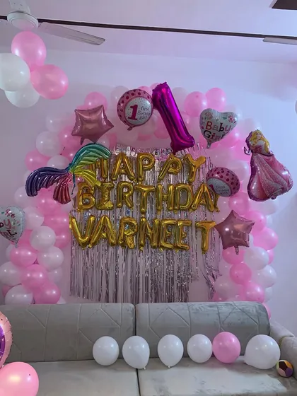 Another view of the princess-themed birthday decor, showing how we can transform a living room into a festive party space using a balloon wall and themed foil balloons.