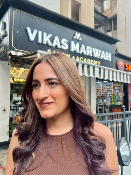 The client enjoying her new look outside the salon. The natural light shows off the subtle purple tones in her hair, and she looks fantastic.