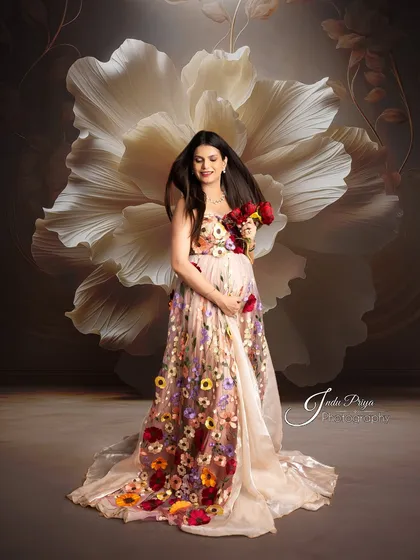 Here, I used a large floral prop and a wind effect to add drama to the portrait. The mom-to-be holds a bouquet of red roses, her hair blowing gently as she looks off-camera.